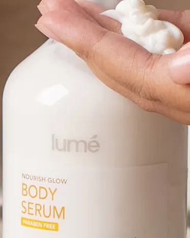 Ujung jari dengan serum putih di atas botol Body Serum 300 gr