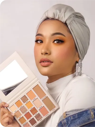 Model bersorban abu-abu dan jaket denim memegang palette terbuka