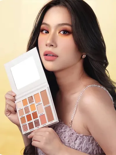 Model berambut panjang dengan atasan berbulu lilac memegang palette terbuka