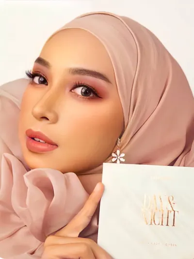 Model berhijab pink memegang kotak Day & Night