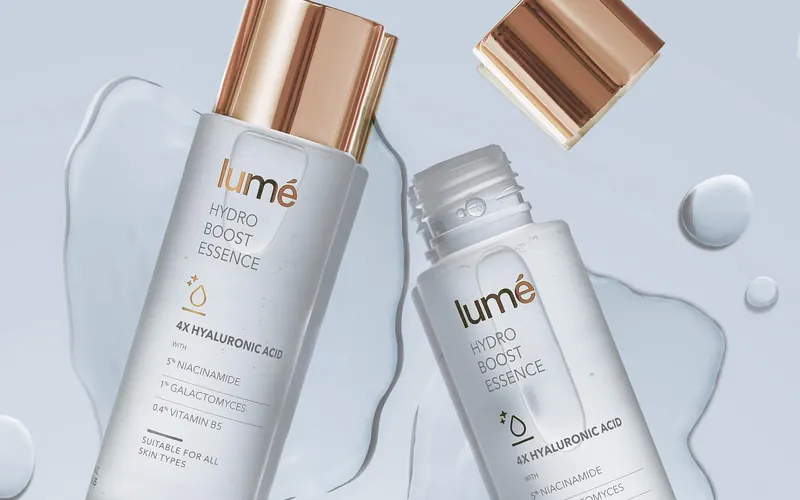 Dua botol Hydro Boost Essence berbaring di genangan essence bening