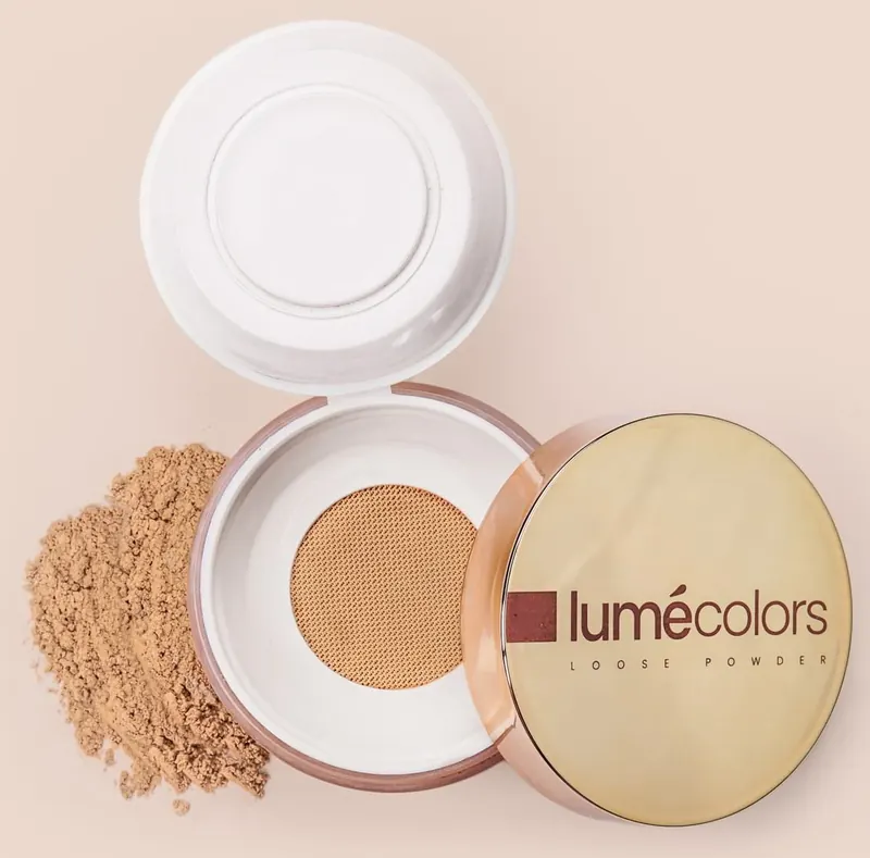 Jar Lumécolors Loose Powder terbuka dengan jaring bedak, tutup emas dan bubuk bedak di sampingnya
