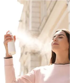 Wanita menyemprotkan setting spray ke wajahnya