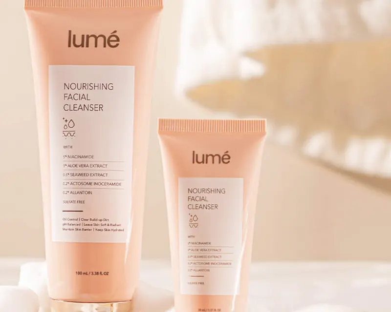 Nourishing Facial Cleanser ukuran 100 mL dan 30 mL di atas potongan kayu