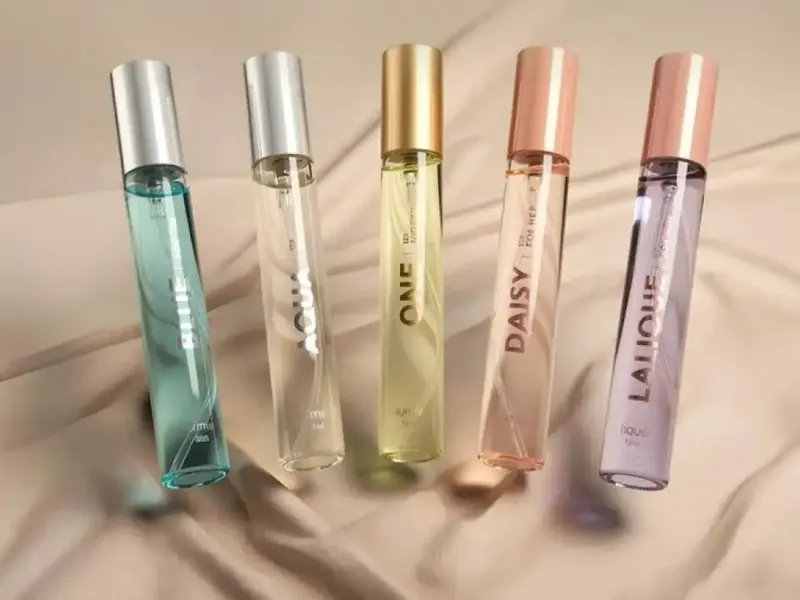 Lima botol parfum Lume 15 mL di atas kain satin