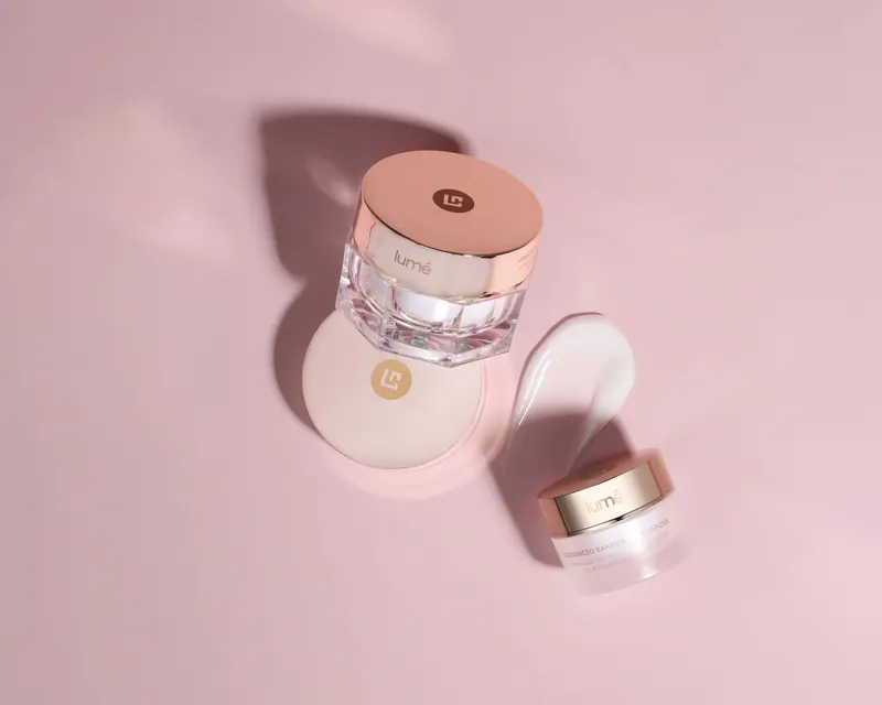 Jar Lume Advanced Barrier Moisturizer dan olesan krim di atas latar merah muda